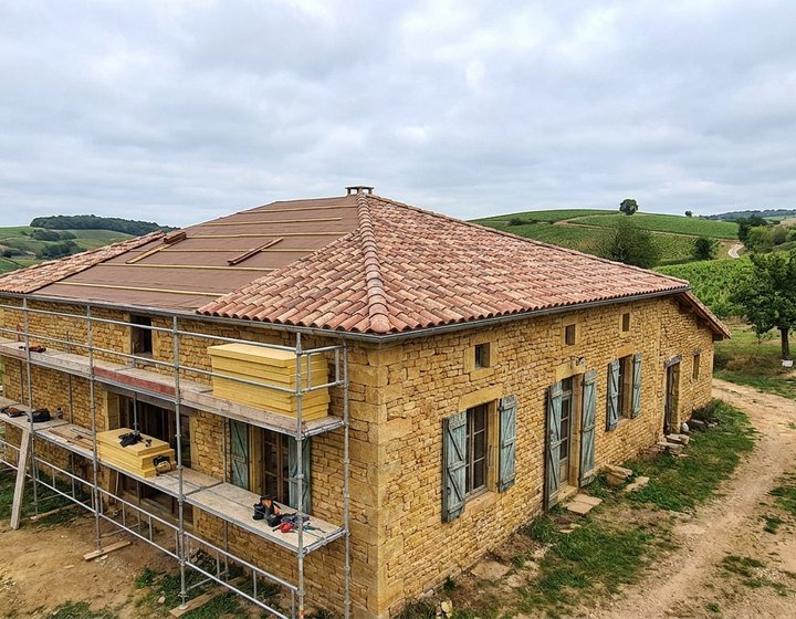 Maison ancienne en pierre de la métropole lyonnaise en cours de rénovation énergétique, façade et toiture reprises