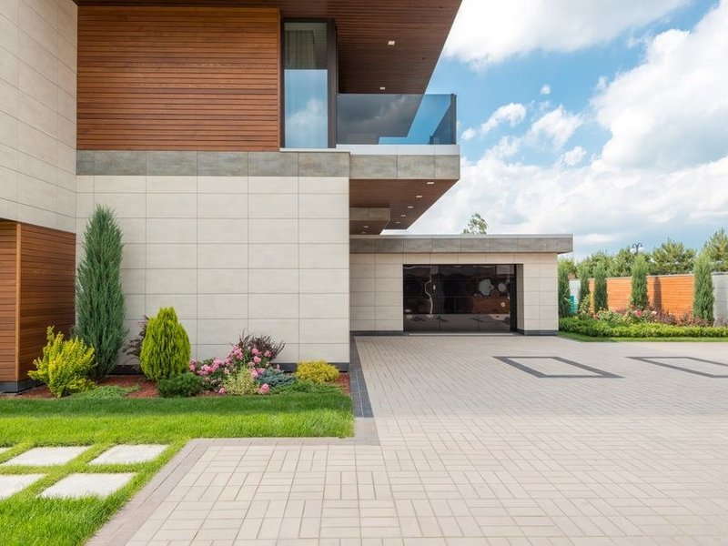 Terrasse extérieure carrelée sur plots au-dessus d'un garage en contrebas, avec margelle et nez de dalle, sur le coteau de Caluire