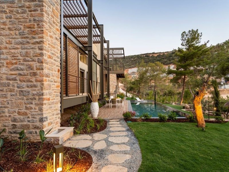 Terrasse de villa de plain-pied carrelée en grès cérame antidérapant autour de la piscine d'une propriété à Charbonnières-les-Bains
