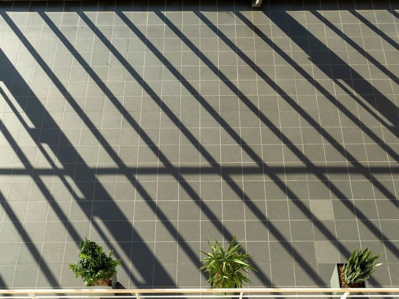 Grès cérame grand format posé dans le séjour d'un pavillon de versant de Courzieu, prolongé jusqu'à la terrasse ombragée