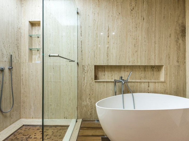 Sol en pierre naturelle travertin clair posé dans une salle de bain de suite parentale d'une villa d'Écully, calepinage régulier