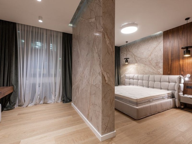Suite parentale d'une propriété d'Écully avec sol en pierre naturelle marbre veiné, salle de bain attenante habillée de travertin
