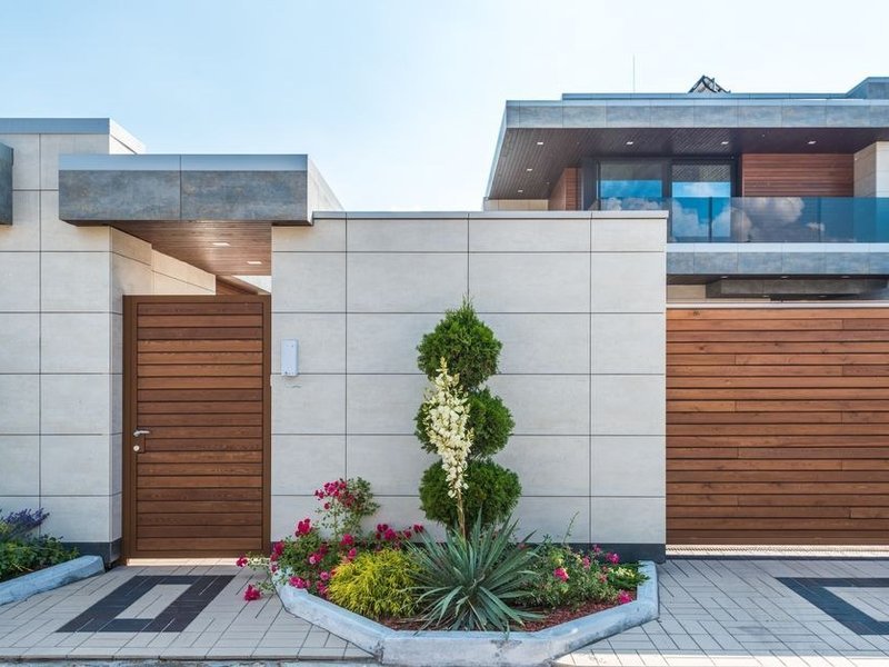 Terrasse carrelée en grès antidérapant côté jardin d'un pavillon feyzinois, dans le prolongement du séjour