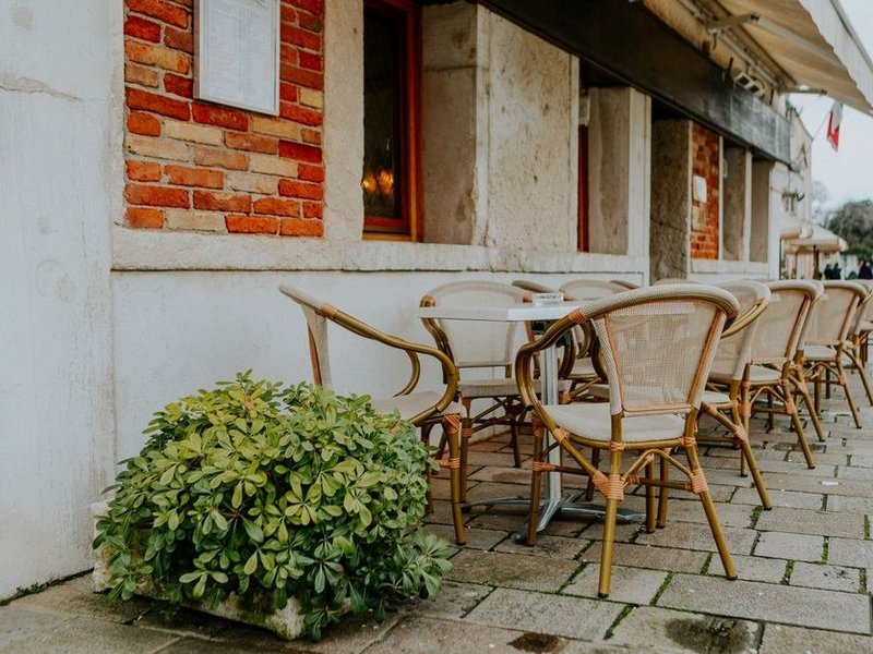 Terrasse de jardin carrelée en grès ingélif sous les arbres du vallon de l'Yzeron à Francheville, pente dirigée vers le jardin