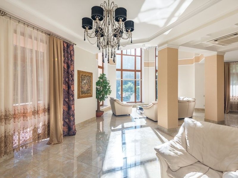 Séjour d'une villa des Monts d'Or à Limonest carrelé en grès cérame grand format clair, longues perspectives filant vers les baies ouvertes sur les coteaux