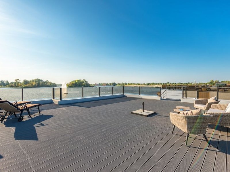 Terrasse suspendue carrelée en dalles de grès sur plots avec vue sur les darses de Confluence à Lyon 2
