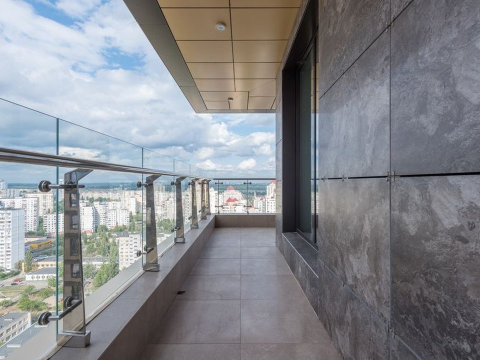 Terrasse carrelée d'un appartement neuf de standing à Confluence à Lyon 2, ouverte sur une vue dégagée de la ville