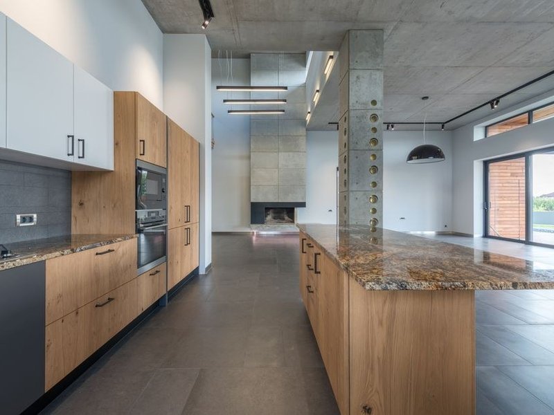 Carrelage grès cérame grand format effet béton posé sans rupture entre la cuisine et le séjour d'un loft de Vaise à Lyon 9