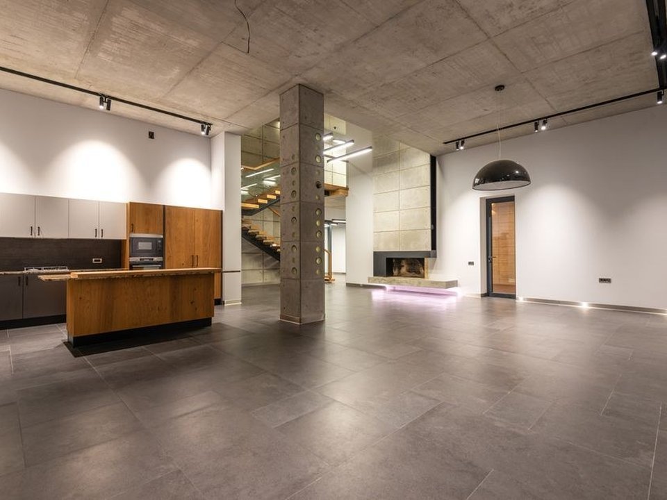 Carreleur posant un grès cérame très grand format effet béton sur la grande dalle d'un loft réhabilité d'un ancien atelier de Vaise à Lyon 9