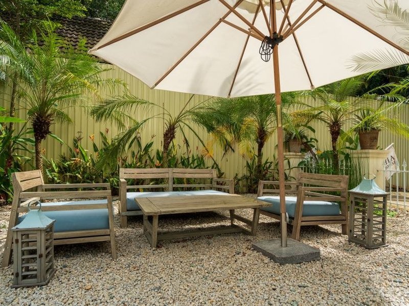 Terrasse en grès cérame antidérapant posée sur plots à l'ombre des arbres d'un jardin de Marcy-l'Étoile