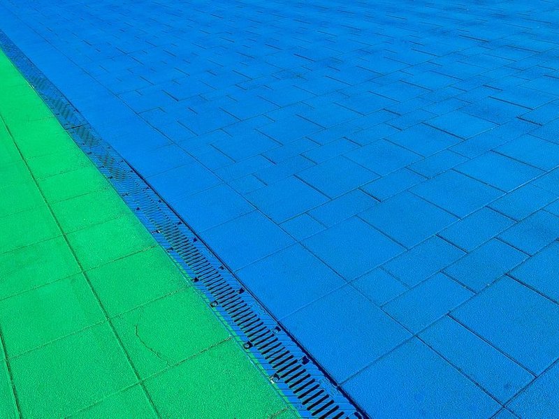 Terrasse d'un pavillon de Meys drainée et mise en pente, carrelée d'un grès résistant au gel face aux prairies