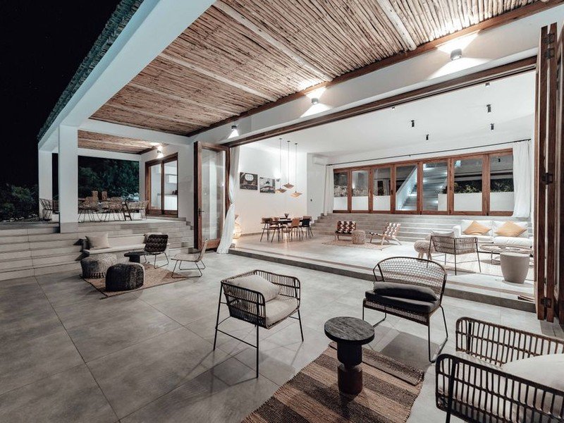 Terrasse de plain-pied carrelée en grès cérame antidérapant devant la baie du séjour d'une maison de Meyzieu, continuité de teinte avec l'intérieur