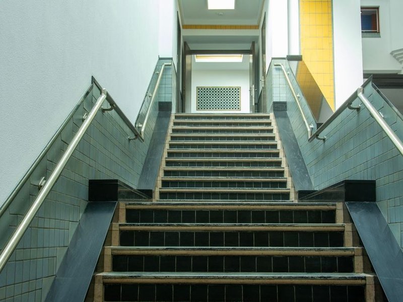 Escalier intérieur habillé de carrelage reliant deux demi-niveaux dans une maison de coteau de Montagny, nez de marche protégé