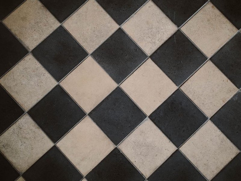 Sol carrelé à damier noir et blanc posé dans une pièce d'un pavillon de Saint-Genis-Laval