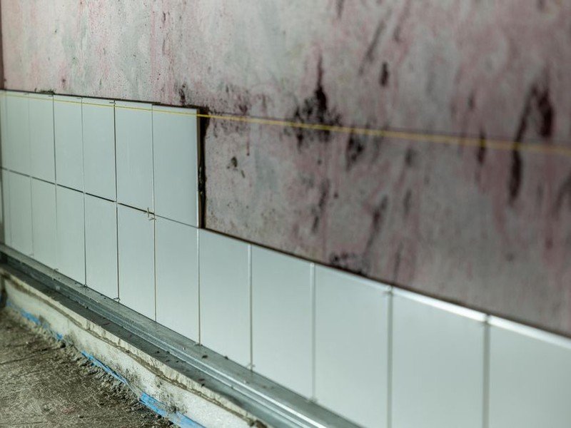 Dépose de l'ancien carrelage d'un sol d'appartement de grand ensemble sur dalle béton à Vénissieux, gravats évacués en sacs