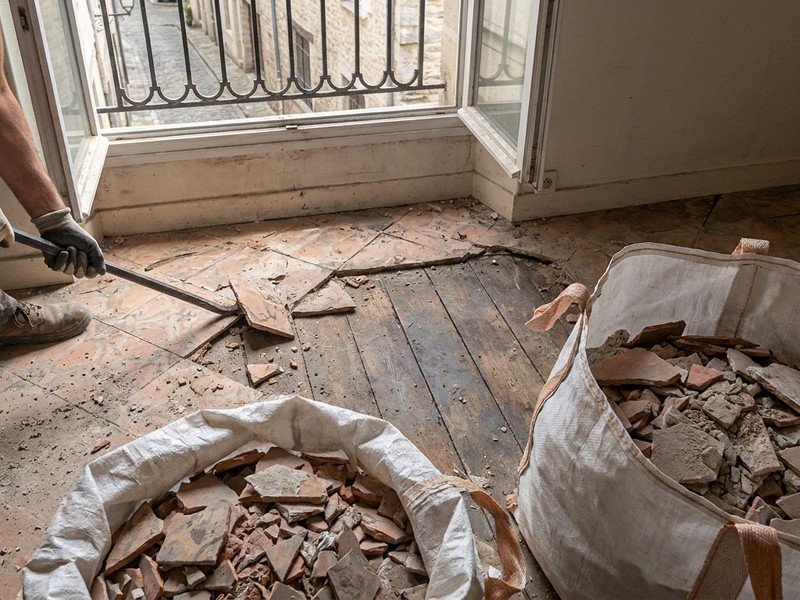 Dépose de l'ancien carrelage sur le plancher bois d'un appartement en étage à Villeurbanne, gravats évacués par sacs