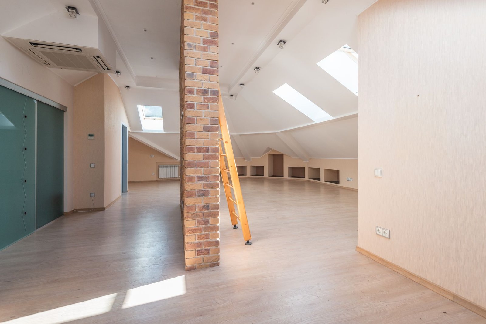 Combles aménagés à Lyon : grande pièce sous pente avec Velux et parquet