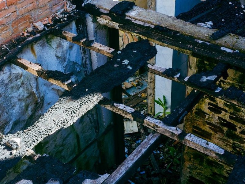 Reprise ponctuelle d'un chevron de charpente noirci par l'humidité retenue sous la couverture d'une maison de coteau à Chaponost