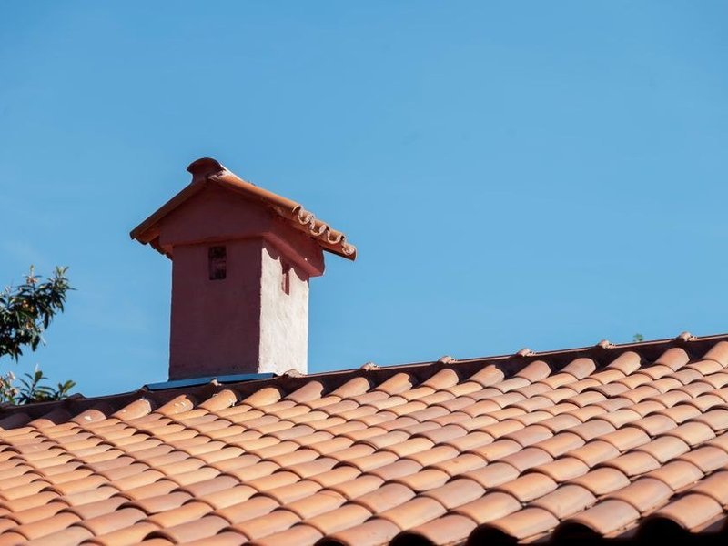 Raccord de souche sur une toiture en tuile d'un hameau de Courzieu, point d'infiltration à reprendre