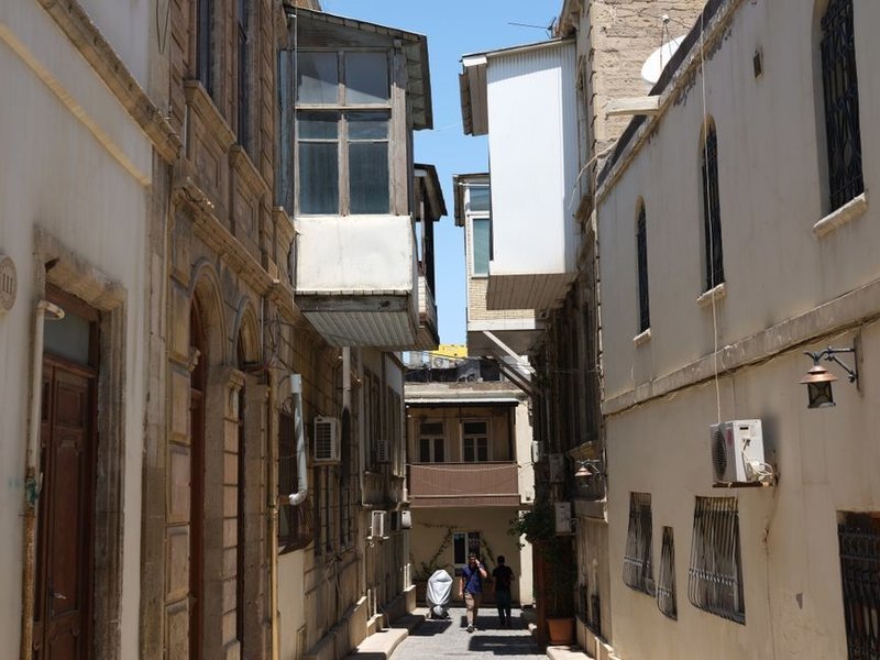 Immeubles anciens serrés d'une rue en pente à La Mulatière, zinguerie et descentes exposées