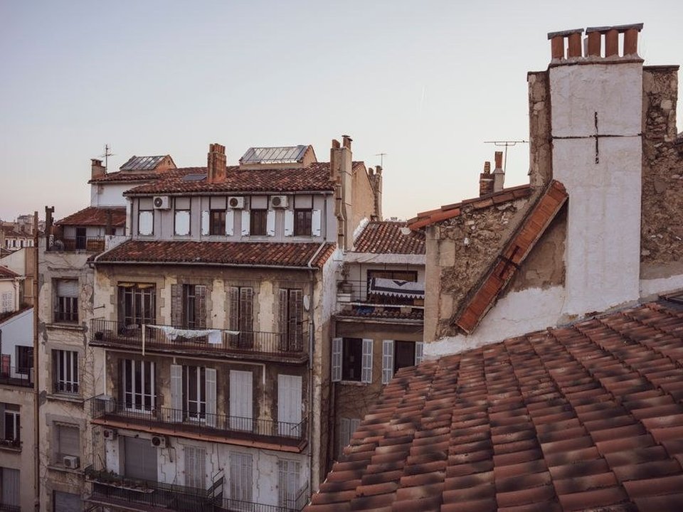 Toiture en tuile mécanique et souche de cheminée d'un immeuble de rapport des années 30 à Monplaisir, Lyon 8e