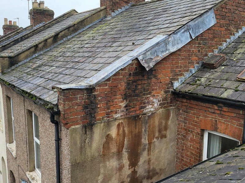 Fuite au niveau d'un solin décollé contre le mur mitoyen d'une maison de bourg ancienne à Oullins avant réfection