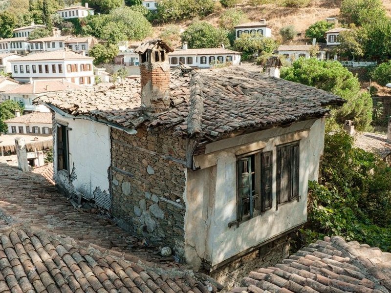 Reprise du faîtage soulevé par le vent au sommet d'une maison du bourg ancien de Saint-Pierre-de-Chandieu