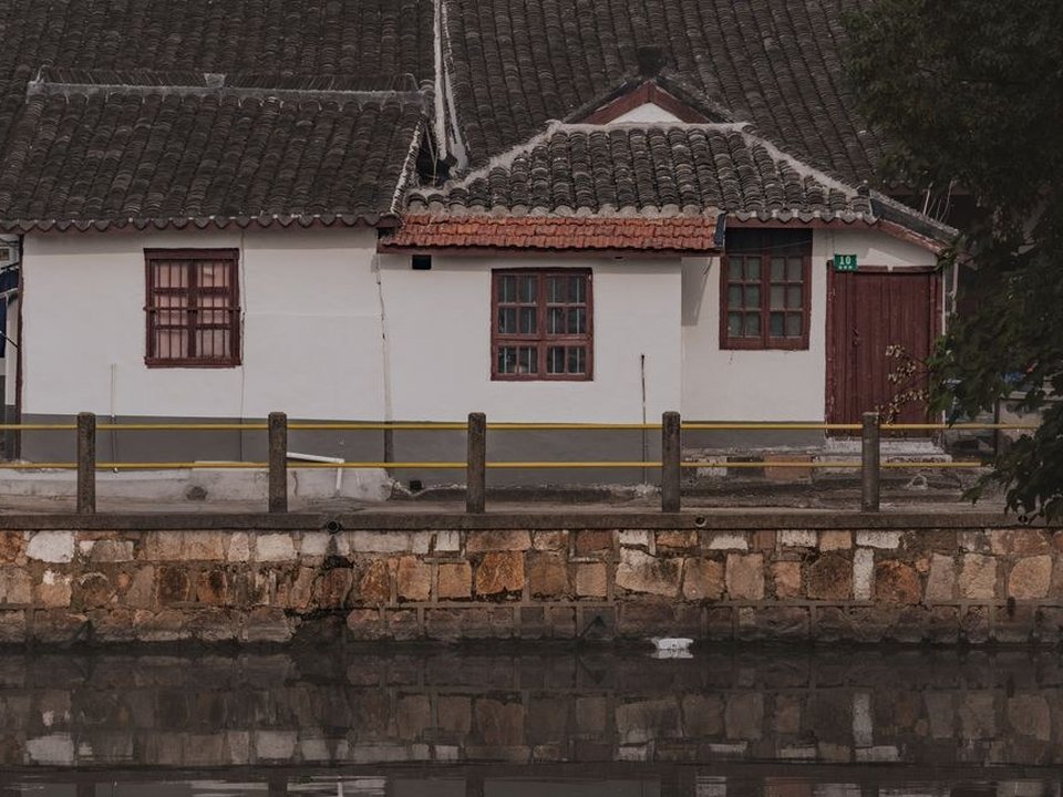Maison de fond de vallée à Souzy, toiture en tuiles verdie par l'humidité au bord de la Brévenne