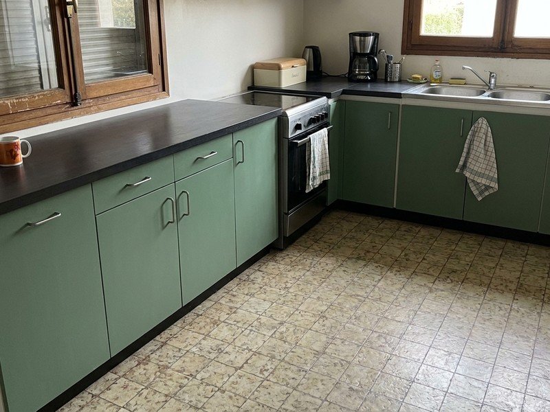 Cuisine fermée d'un pavillon des années 60 à Bron rééquipée en cuisine équipée fonctionnelle, façades neuves et plan de travail continu, budget maîtrisé