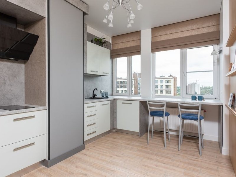 Cuisine ouverte d'un pavillon du plateau à Chevinay, îlot central face au séjour, large baie cadrant la vue dégagée sur les prairies et les crêtes des Monts du Lyonnais