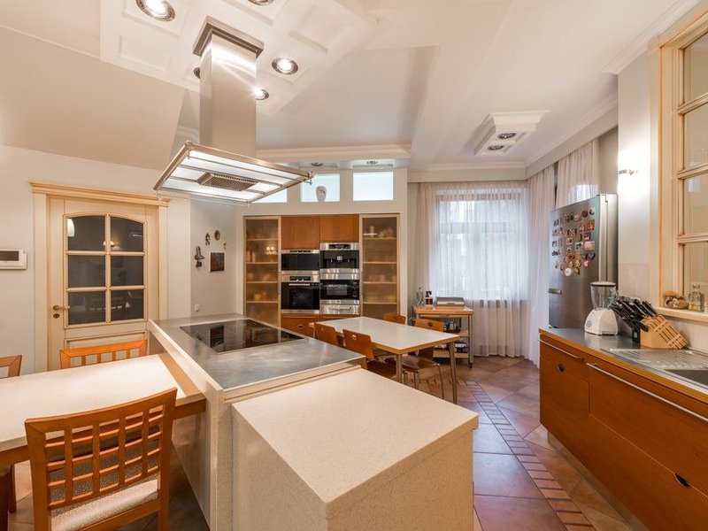 Îlot avec coin repas dans une cuisine de plain-pied à Communay, façades pleines assorties au séjour et hotte encastrée, village des coteaux du sud lyonnais