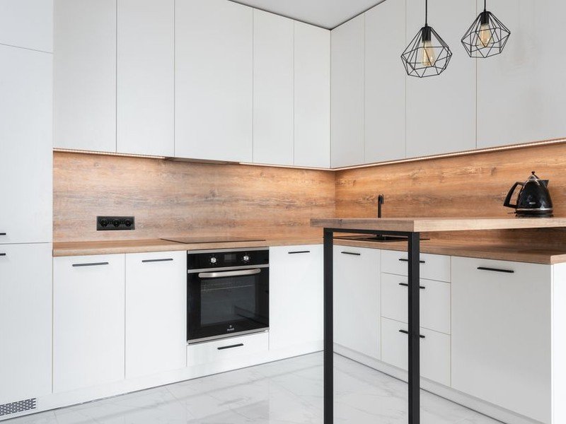 Cuisine équipée neuve posée en L dans un appartement récent de Décines livré sans cuisine, colonnes toute hauteur et électroménager encastré sur une surface optimisée