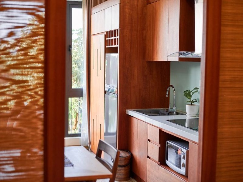 Cuisine de pavillon à Fontaines-Saint-Martin avec le plan de travail placé face à la baie vitrée ouvrant sur le jardin et la vallée