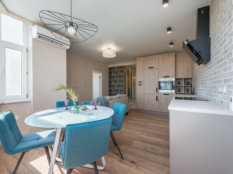 Cuisine de pavillon de lotissement à Fontaines-Saint-Martin ouverte sur le séjour après suppression d'une cloison, plan de travail tourné vers le jardin