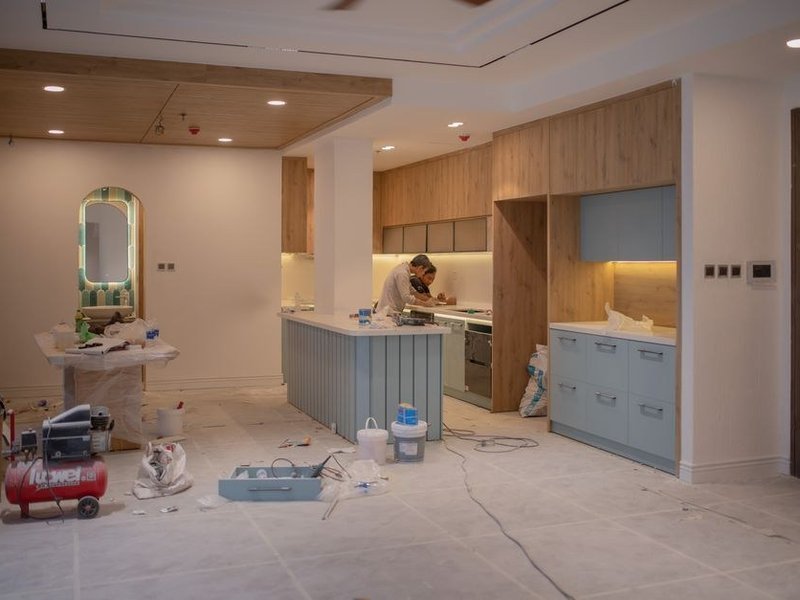 Installation d'un îlot central dans la cuisine d'un pavillon de Genas, arrivée d'eau et évacuation amenées au milieu de la pièce sous la dalle, conduit d'extraction préparé pour la hotte d'îlot avant la pose du plan de travail