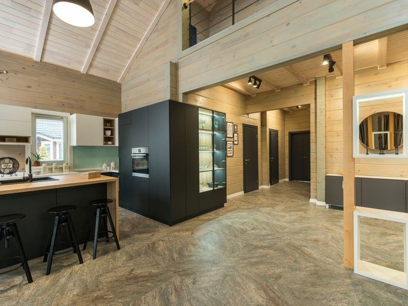 Cuisine familiale à îlot sur mesure dans un pavillon des Peupliers à Genas, façades fabriquées aux cotes, grand plan de travail central prolongé par un coin repas ouvert sur le jardin