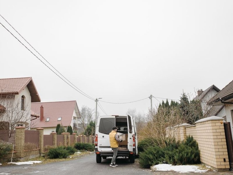 Meubles de cuisine et plan de travail portés le long d'une allée privée en pente d'une villa des coteaux boisés d'Irigny, marches de jardin et camion garé en contrebas