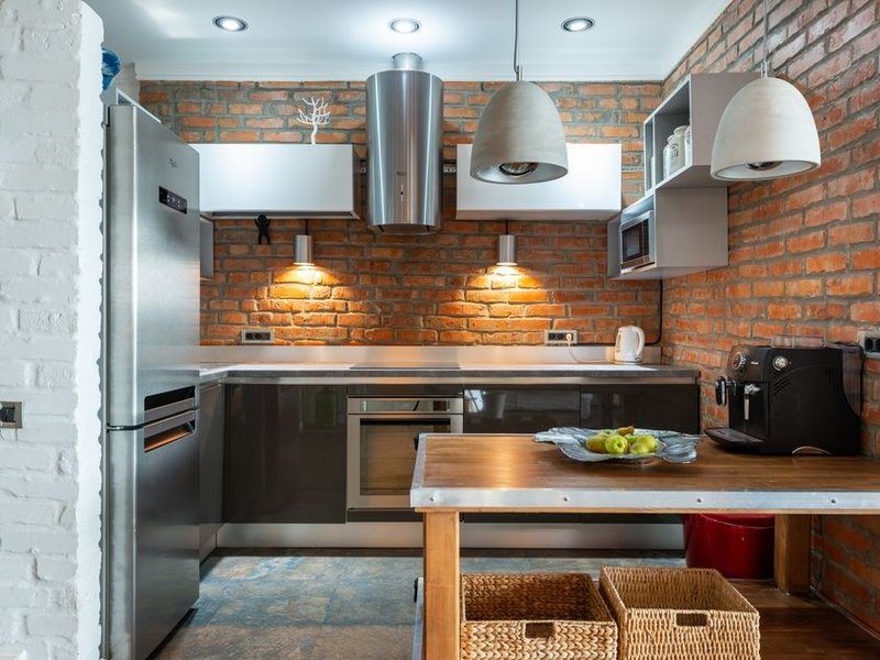 Cuisine rénovée dans une maison ancienne en pierre du vieux bourg perché d'Irigny, meubles ajustés aux murs épais et embrasures profondes, esprit du lieu préservé