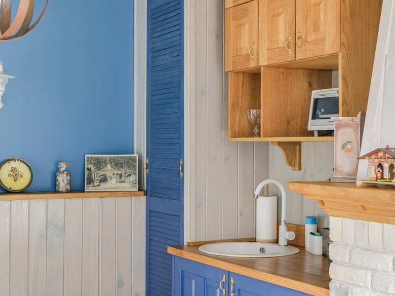 Petite cuisine rénovée d'une maison de bourg ancienne de Lentilly, meubles ajustés aux murs de travers, teintes claires pour récupérer le jour, ambiance de vieux village