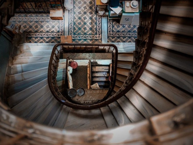 Éléments de cuisine montés à la main dans une cage d'escalier ancienne en colimaçon d'un immeuble de canut des Pentes de la Croix-Rousse à Lyon 1, colonnes recoupées pour passer les tournants serrés