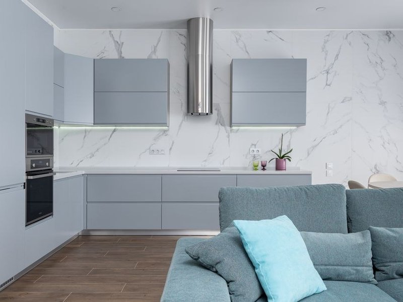 Petite cuisine en L d'un appartement de canut des Pentes de la Croix-Rousse à Lyon 1, rangements sur le mur aveugle et plan de travail sous la haute fenêtre d'atelier laissée dégagée