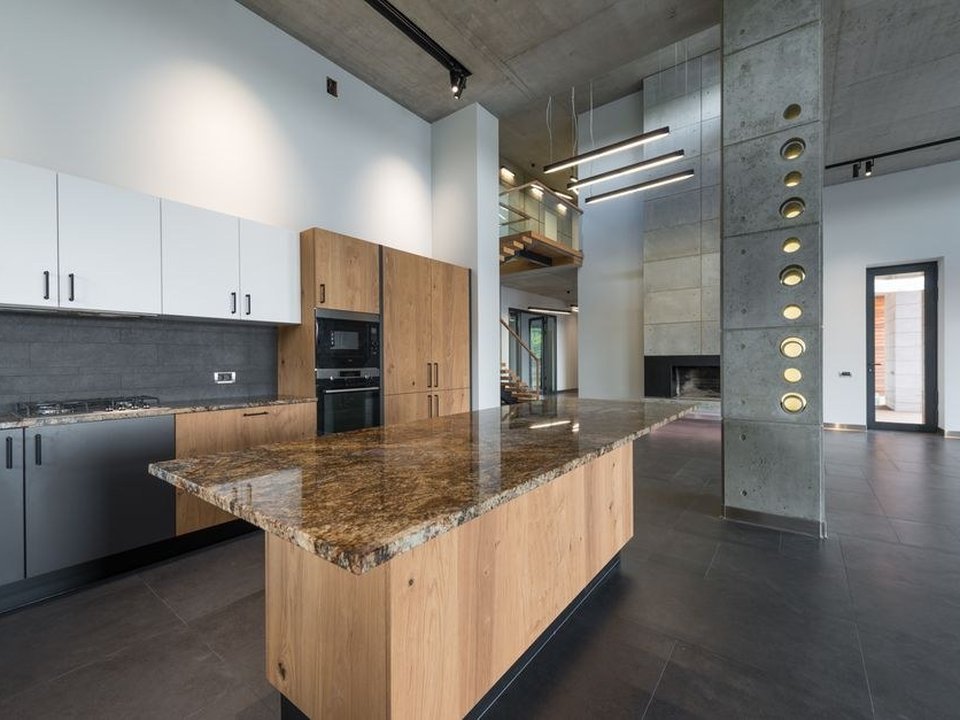 Cuisine agencée sous une très grande hauteur sous plafond dans un appartement de canut de la Croix-Rousse à Lyon 4, rangements montés très haut, poutres et pierre apparentes conservées
