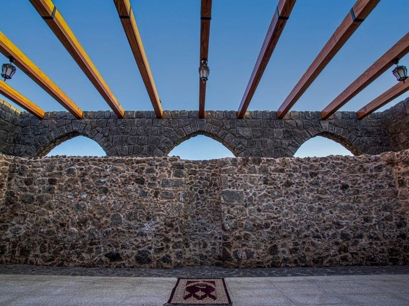 Ouverture pratiquée dans un mur de pierre épais d'un immeuble Renaissance du Vieux-Lyon, poutre posée pour reprendre la charge, embrasure profonde en pierre et sol ancien conservés