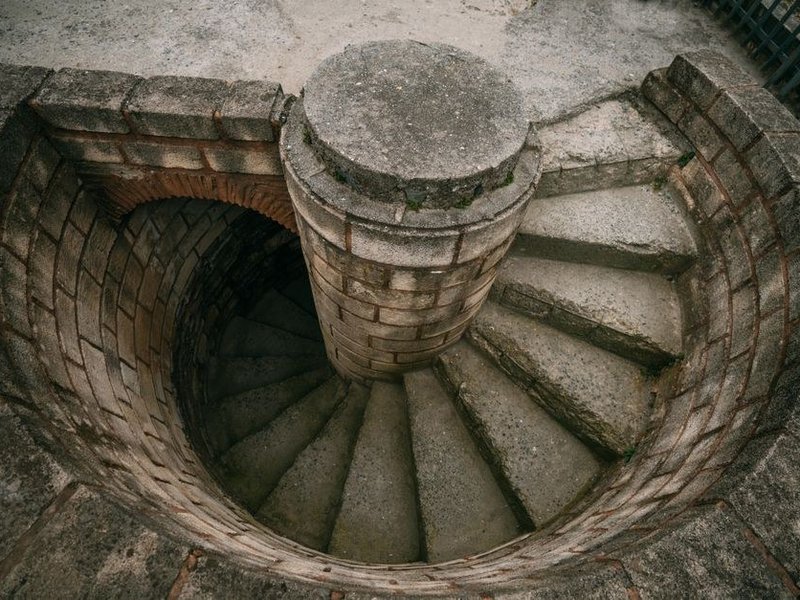 Éléments de cuisine montés à la main par un escalier à vis en pierre d'un immeuble Renaissance du Vieux-Lyon, colonnes recoupées pour passer les tournants serrés de la cage ancienne