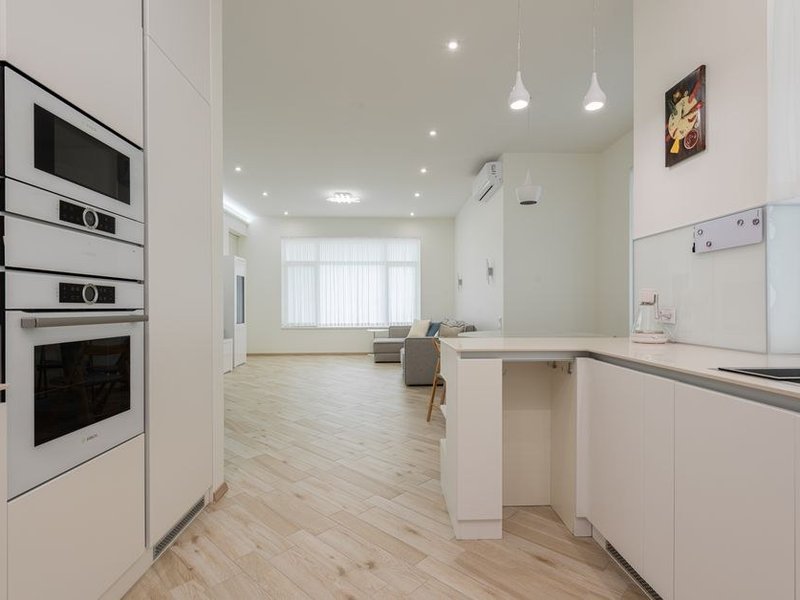 Cuisine sur mesure posée dans une pièce biscornue d'un appartement ancien de Saint-Just sur les coteaux du 5e, meubles fabriqués aux cotes pour rattraper les angles et les embrasures profondes