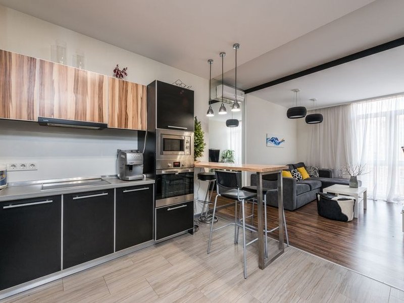 Cuisine sur mesure aux colonnes toute hauteur montant jusqu'à la corniche d'un appartement haussmannien de l'avenue Foch à Lyon 6, parquet point de Hongrie et grande hauteur sous plafond conservés