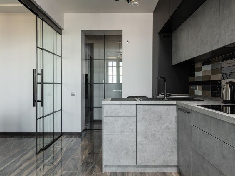 Verrière atelier rythmant l'ouverture entre la cuisine et le séjour d'un appartement bourgeois de Masséna à Lyon 6, calée sur les moulures et la hauteur sous plafond, esprit haussmannien préservé