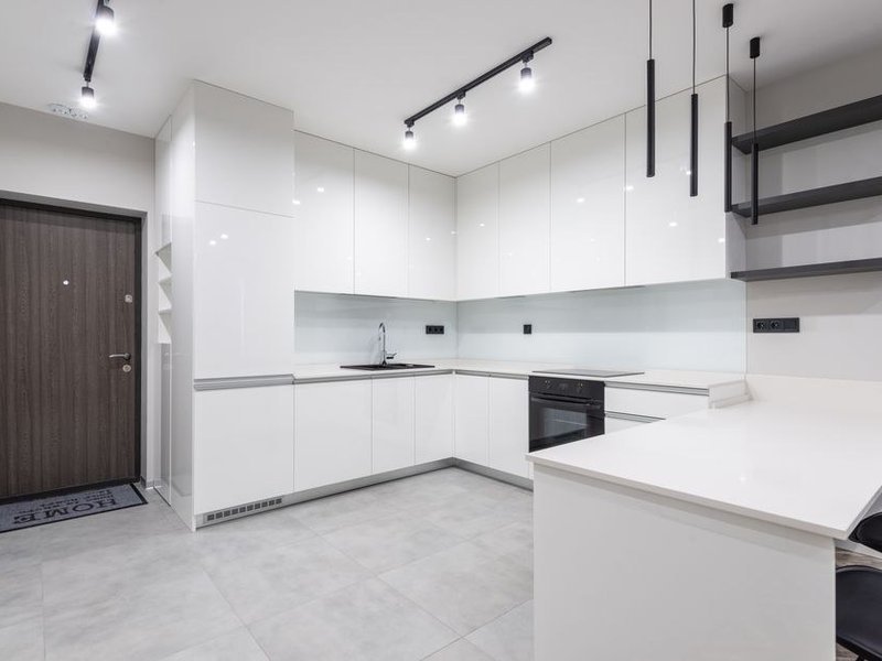 Petite cuisine linéaire d'un appartement ancien exigu de la Guillotière à Lyon 7 optimisée sur un seul mur, rangements montés jusqu'au plafond, réfrigérateur sous plan et plaque de cuisson compacte