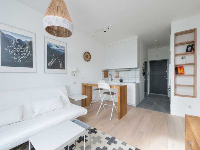 Kitchenette compacte posée en I dans un studio locatif ancien de la Guillotière près de Jean Macé à Lyon 7, plan de travail filant et meubles hauts jusqu'au plafond pour gagner du rangement