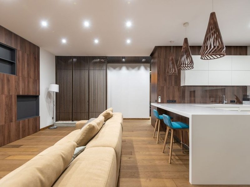 Cuisine d'un appartement de Monplaisir à Lyon 8 ouverte sur le séjour après abattage d'une cloison non porteuse, plan de travail et rangements neufs dans un immeuble des années 1930-50 remis à niveau